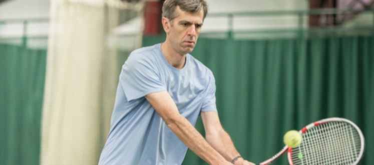 A man playing indoor short tennis