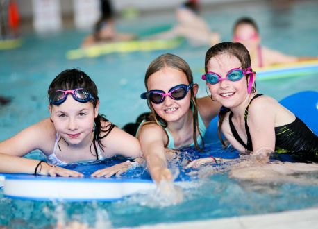 3 teenagers on floats in a pool