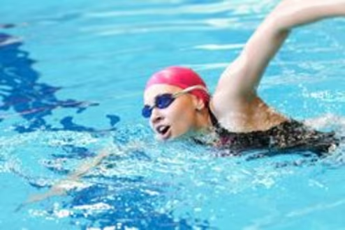 Women swimming in red swimming cap and googles