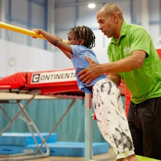 A trampoline behind the young gymnast.