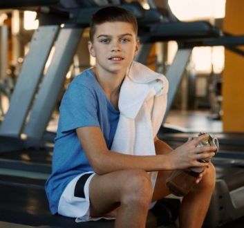 Junior gym session - boy sat on treadmill