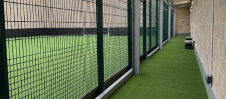seating area overlooking a 3g football pitch with green surface and goals
