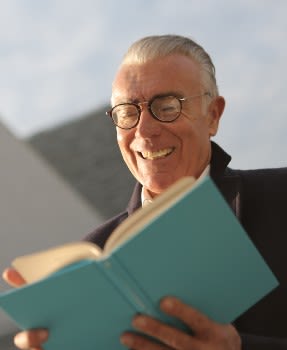 Man in his 60s reading a blue book