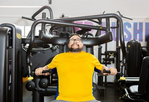 Male gym member using a weight machine in the gym