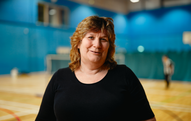 Woman in a sports hall wearing a black t-shirt