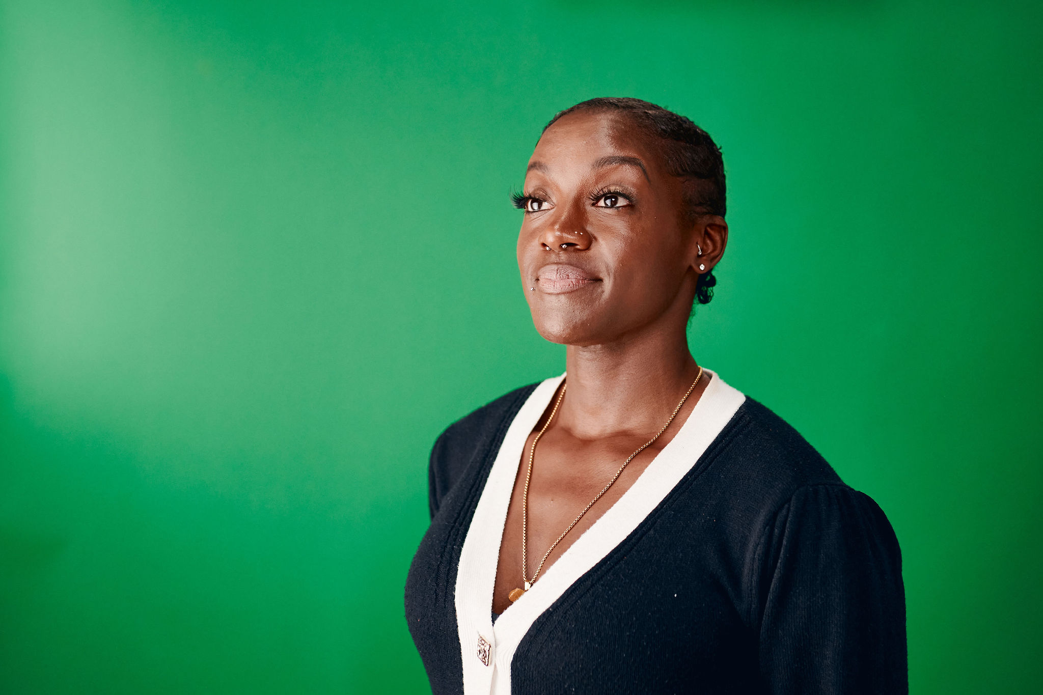 A woman standing in front of a green back drop A woman standing in front of a green back drop