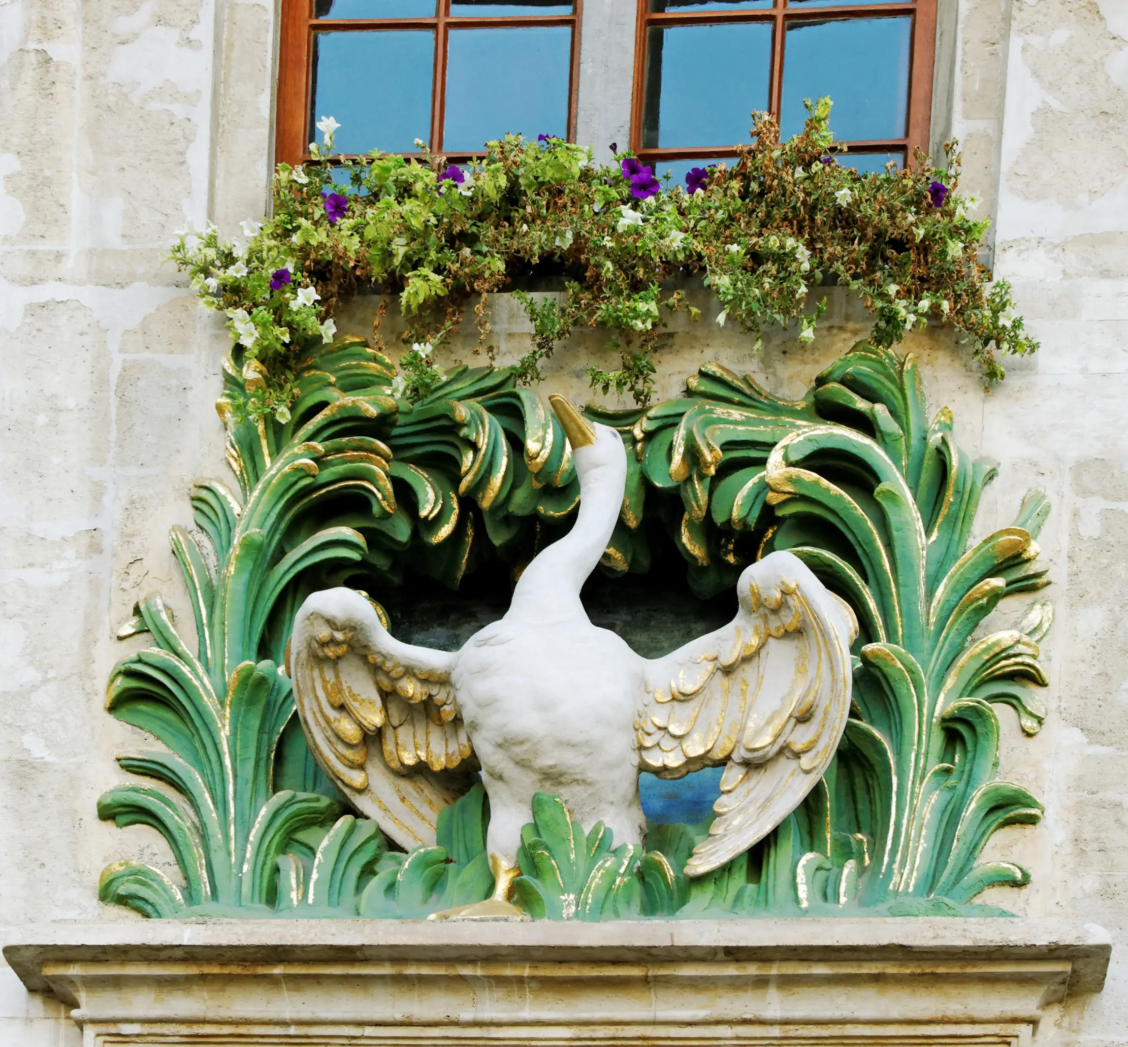 A Sculpture of a White Goose with Gold and Green Trim