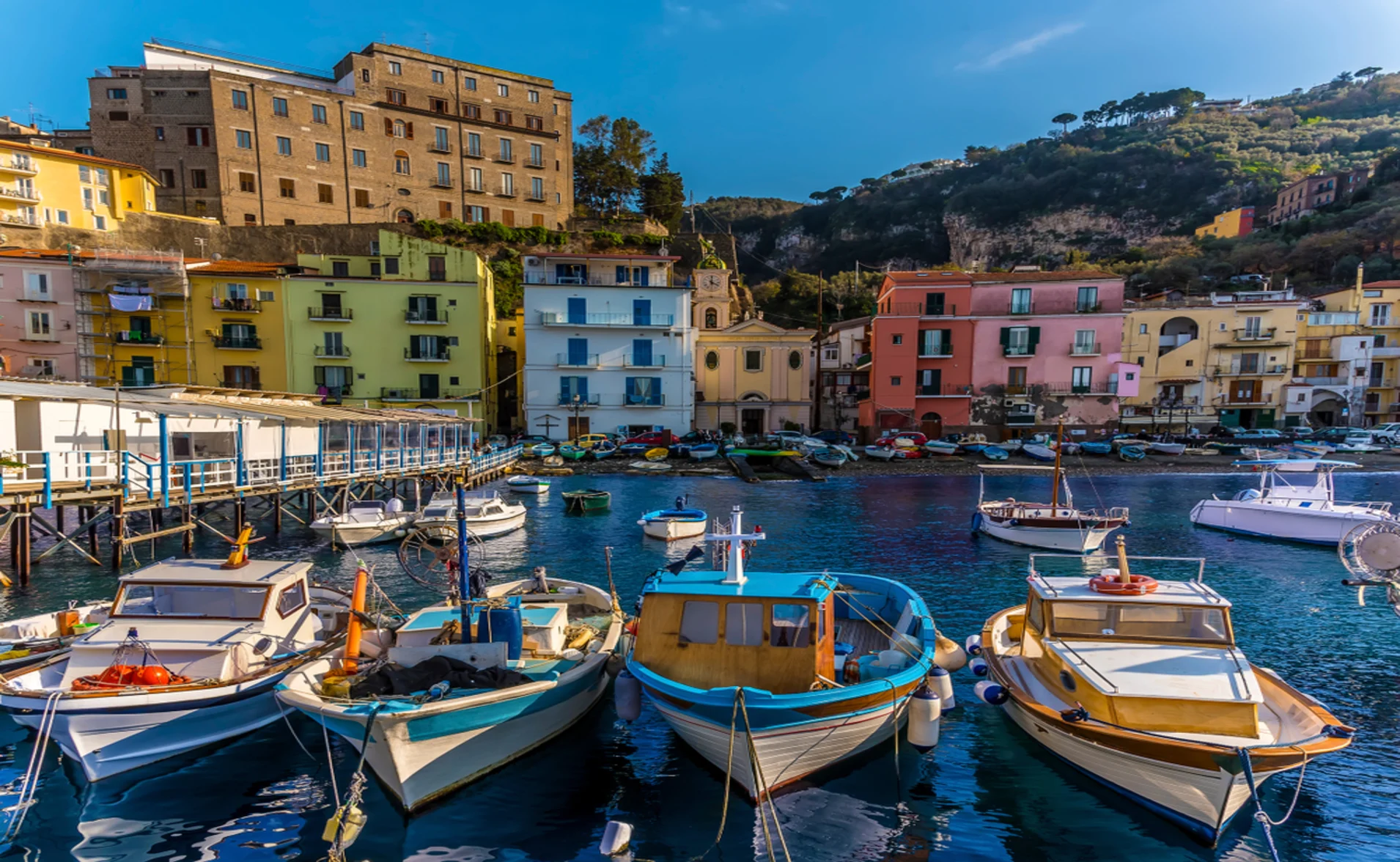 boats in a marina and colorful houses in sorrento italy 