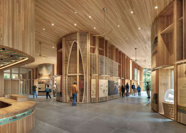 Inside a wooden structure with people looking at exhibition.