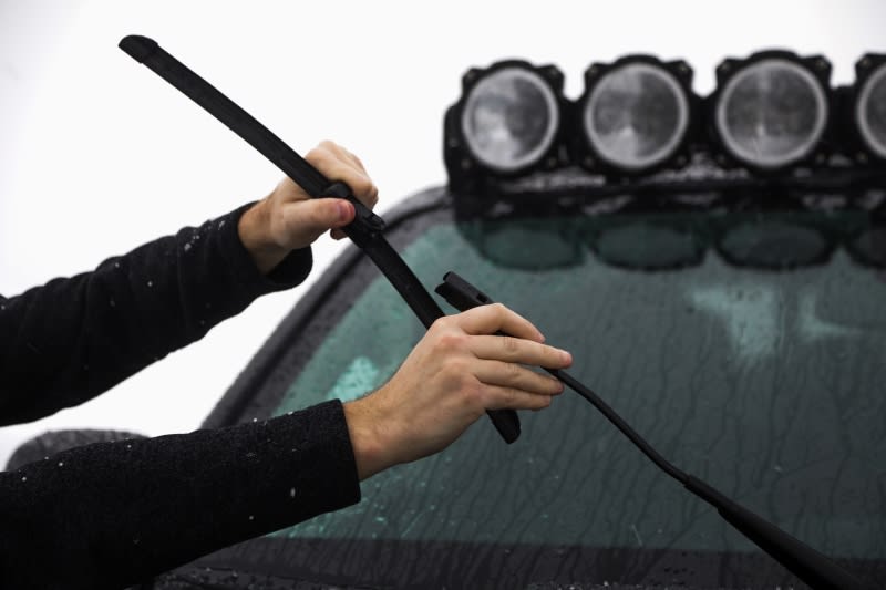Person installing windshield wipers on truck