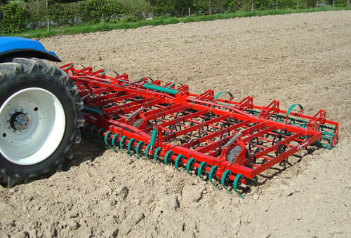 Seedbed Cultivators - Tractor pulling Kverneland TLD plough on field during operation