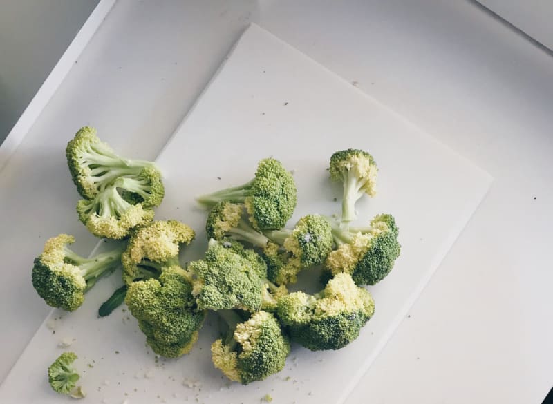 yellow and discolored broccoli on white cutting board