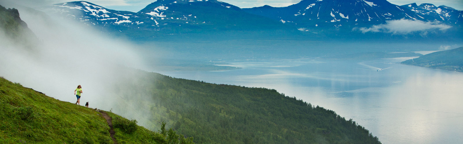 Jogger on a mountain trail in Norrona technical workout clothes for an active lifestyle