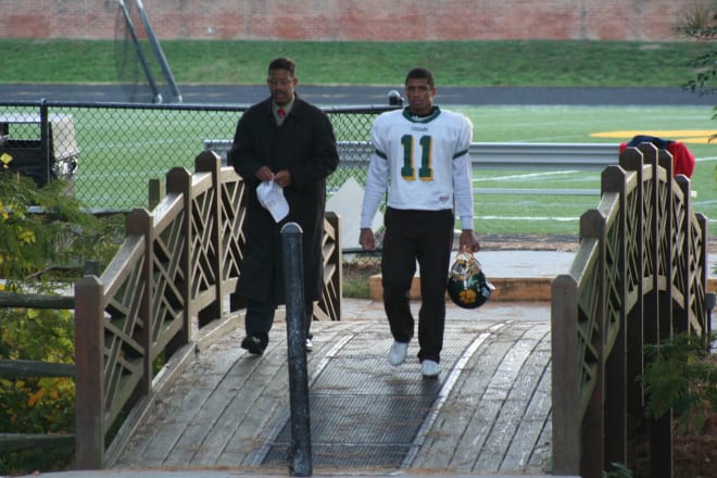 Former NC State Wolfpacker quarterback Russell Wilson walks off the high school field with his father.