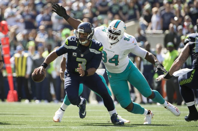 Former NC State football star defensive end Mario Williams makes a tackle