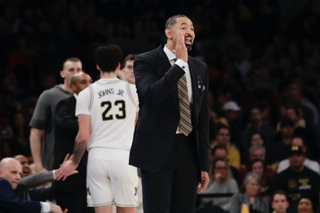 Michigan Wolverines basketball coach Juwan Howard shouts out instructions.