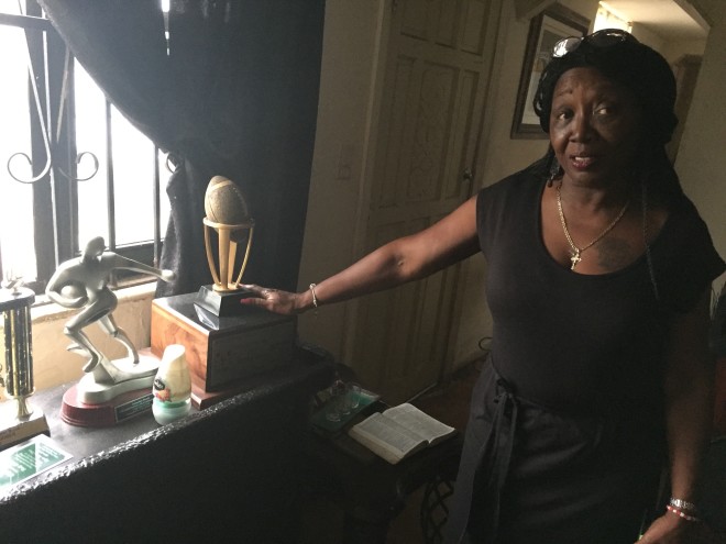 Betty Cook shows off the various youth football awards displayed in her living room.