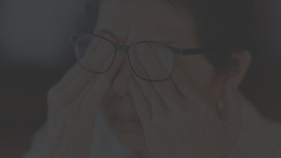 senior woman rubbing her eyes under glasses