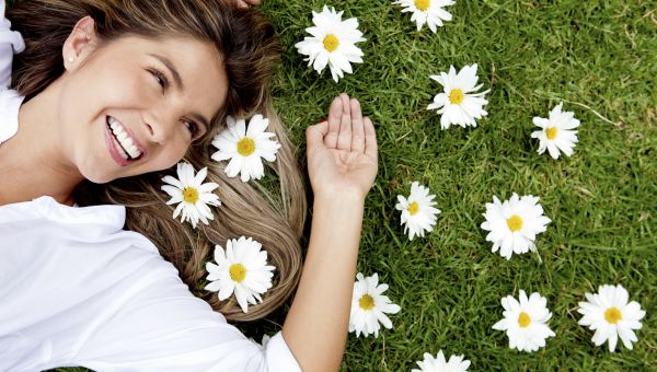 woman laying in the grass with daisy flowers in her hair