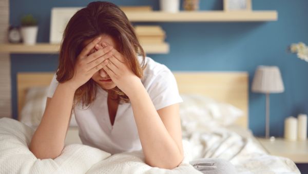 woman sitting on bad, sad