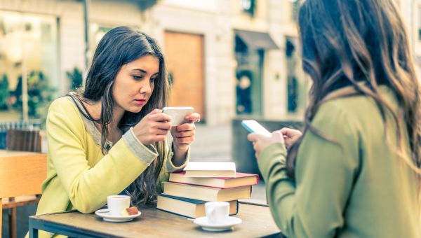 two girls on their smart phone at lunch