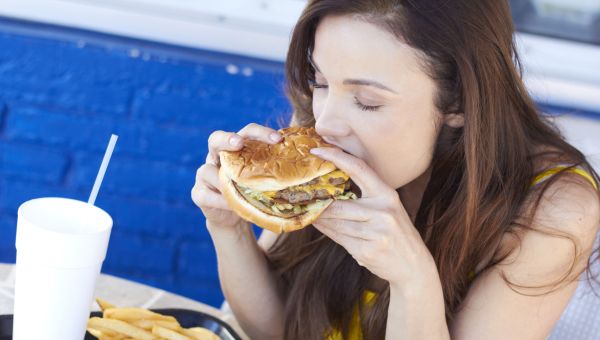 woman eating fries, burgers, cola