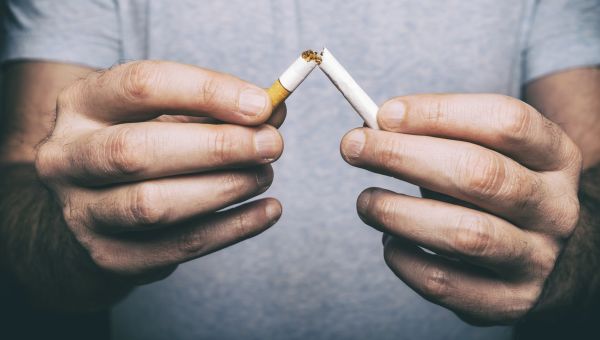 Quitting smoking - male hand crushing cigarette