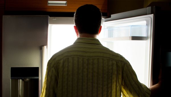 man looking in empty fridge