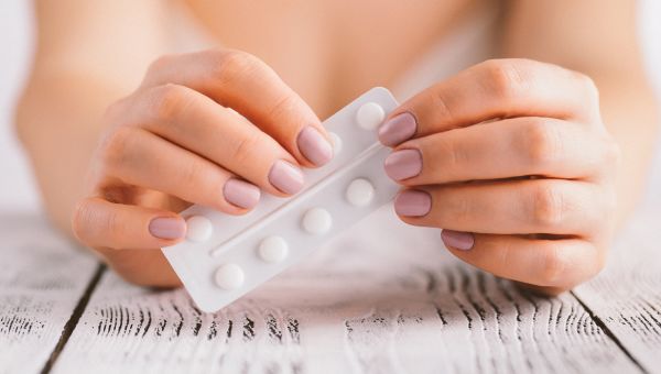 Close up shot of someone holding a strip of medication pills 