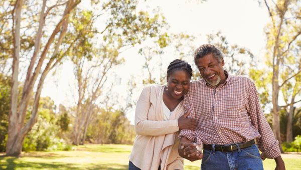 two mature people walking in a park