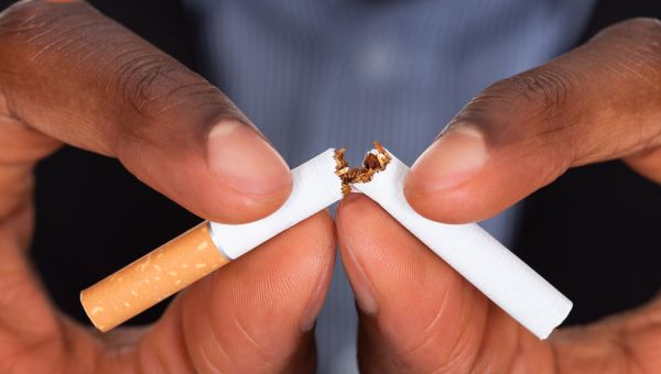 man breaking a cigarette in half