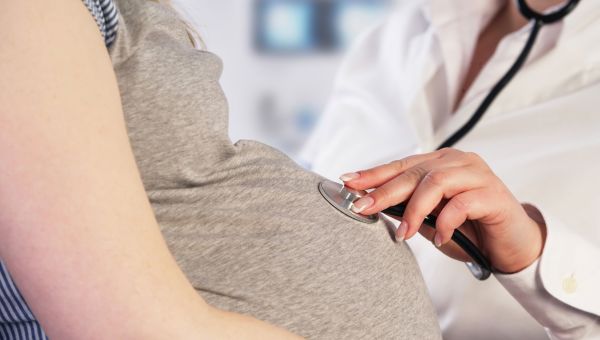 doctor listening to pregnant woman's baby