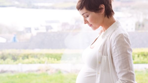 pregnant woman staring down at baby bump