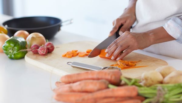 Someone preparing vegetables in kitchen