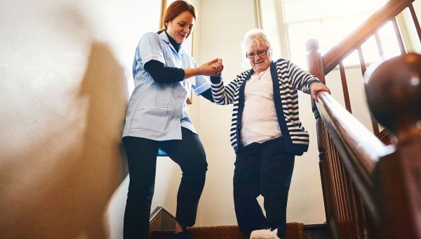 nurse helping elderly walk