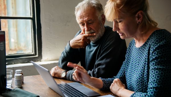 Senior couple discussing finances and using a laptop