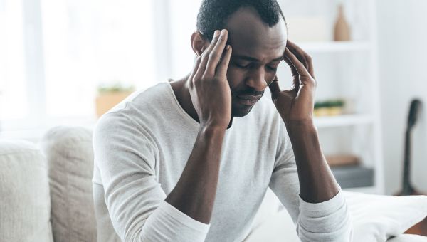 man holding head in hands