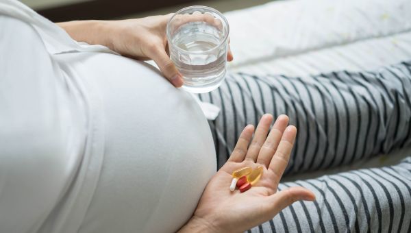 Pregnant person taking vitamins