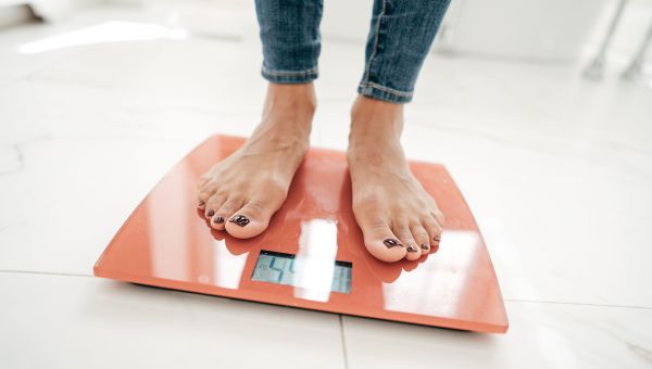 woman weighing herself on scale