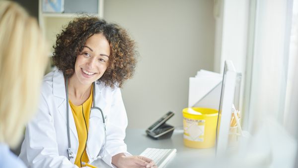 someone talking to an HCP doctor who has curly hair