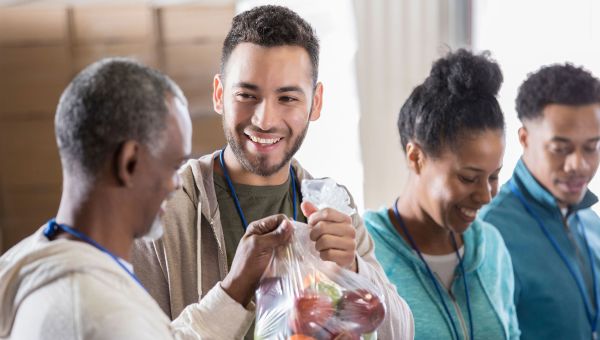Food bank volunteer receives bag of fruit