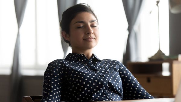 young woman meditating at her desk
