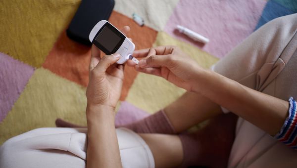 Young man and woman in kitchen checking A1C diabetes blood sugar