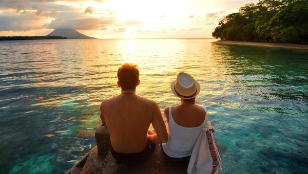 couple sits on beach.