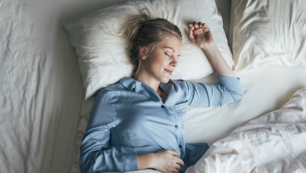 A blonde woman sleeps peacefully in bed