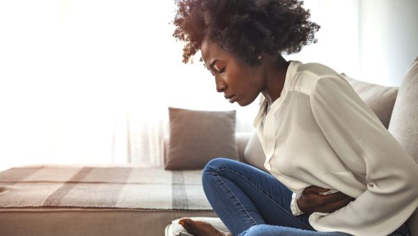 Black person sitting with abdominal pain