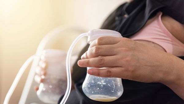 Woman using a breast pump to save milk for newborn instead of breastfeeding.