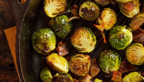 A cast iron filled with healthy roasted Brussel sprouts.