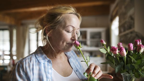 mature woman smelling flowers