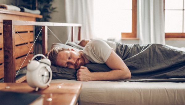 man sleeping in wood bed